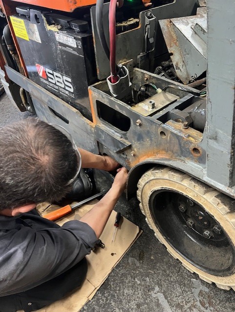 forklift repair technician in milwaukee forking on a lift